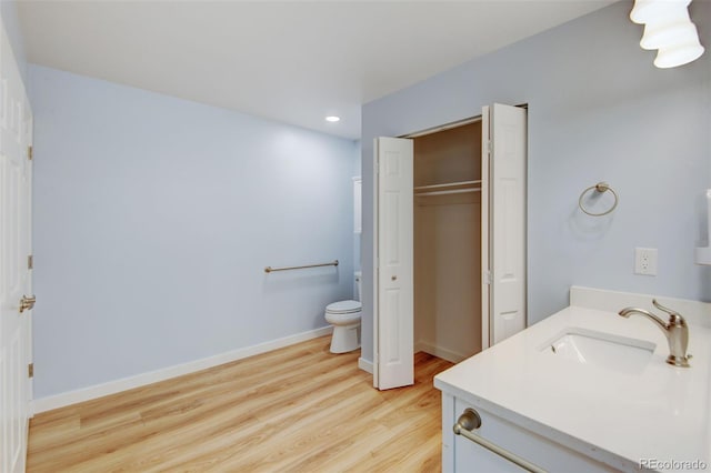 20 Scott Dr, Broomfield, CO 80020 - bathroom featuring vanity, wood finished floors, toilet, baseboards, and recessed lighting