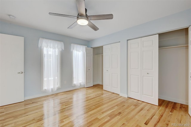 20 Scott Dr, Broomfield, CO 80020 - unfurnished bedroom with two closets, wood finished floors, ceiling fan, and baseboards