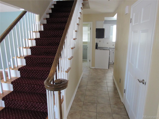 stairway with tile patterned floors