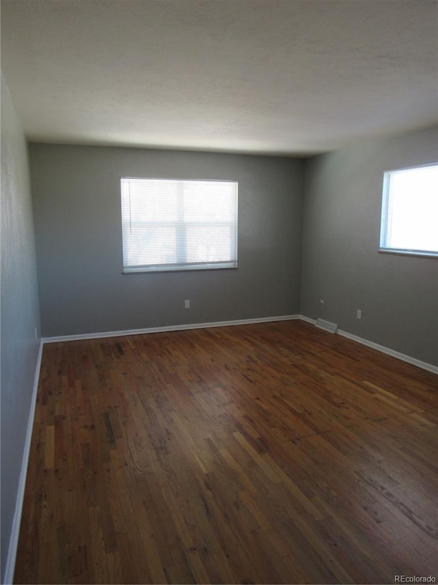 unfurnished room with dark hardwood / wood-style floors