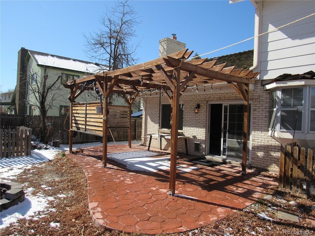 snow covered property featuring a pergola and a patio area