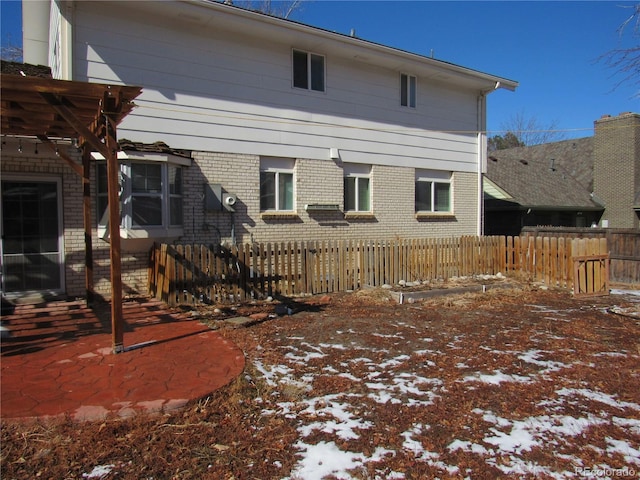 view of snow covered back of property