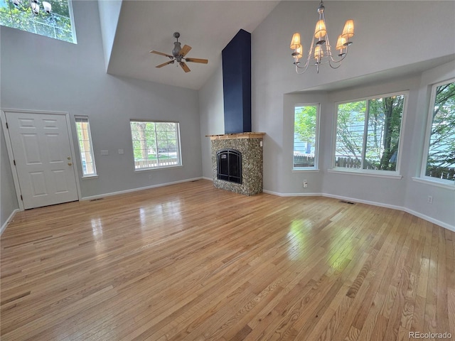 8772 S Carr Way, Littleton, CO 80128 - unfurnished living room featuring high vaulted ceiling, a chandelier, light wood-style floors, ceiling fan, and a high end fireplace