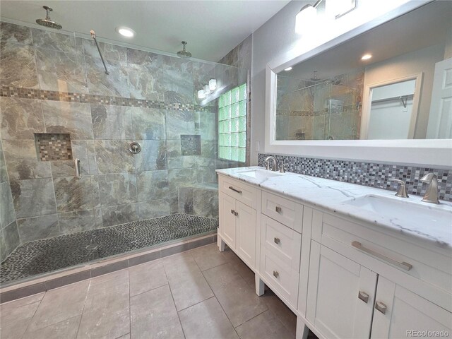 8772 S Carr Way, Littleton, CO 80128 - full bath with a shower stall, double vanity, tile patterned floors, decorative backsplash, and recessed lighting
