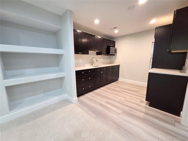 8772 S Carr Way, Littleton, CO 80128 - kitchen featuring stainless steel microwave, a sink, light countertops, light wood-style floors, and baseboards