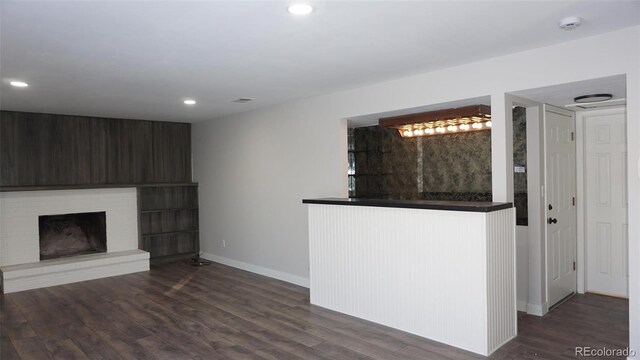 unfurnished living room with dark hardwood / wood-style flooring and indoor bar