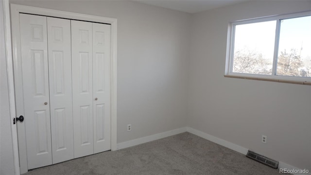 unfurnished bedroom featuring a closet and light carpet