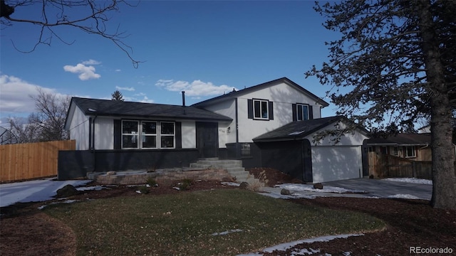 tri-level home with a garage and a front lawn