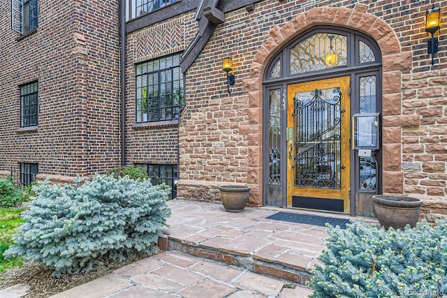 doorway to property featuring brick siding