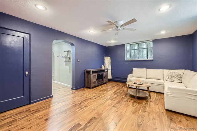 2233 Kearney St Unit 19, Denver, CO 80207 - living area with a ceiling fan, a textured ceiling, arched walkways, light wood-type flooring, and baseboards
