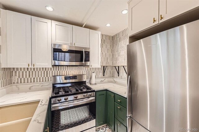 2233 Kearney St Unit 19, Denver, CO 80207 - kitchen with white cabinets, appliances with stainless steel finishes, light stone counters, recessed lighting, and green cabinets
