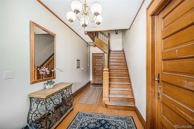 staircase featuring ornamental molding, wood-type flooring, and a textured ceiling