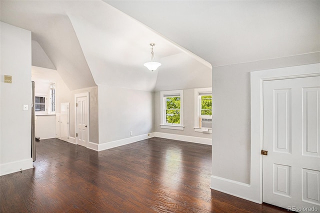 unfurnished living room featuring dark wood-type flooring, vaulted ceiling, and cooling unit