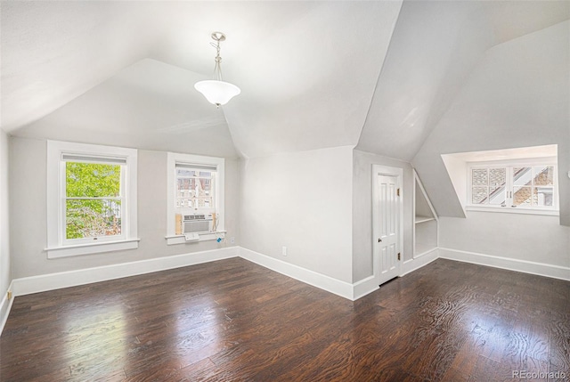 additional living space featuring dark wood-type flooring, lofted ceiling, and cooling unit