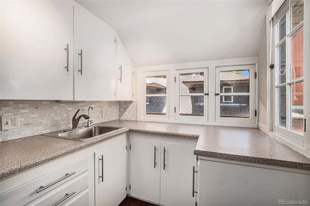 kitchen featuring tasteful backsplash, sink, and white cabinets