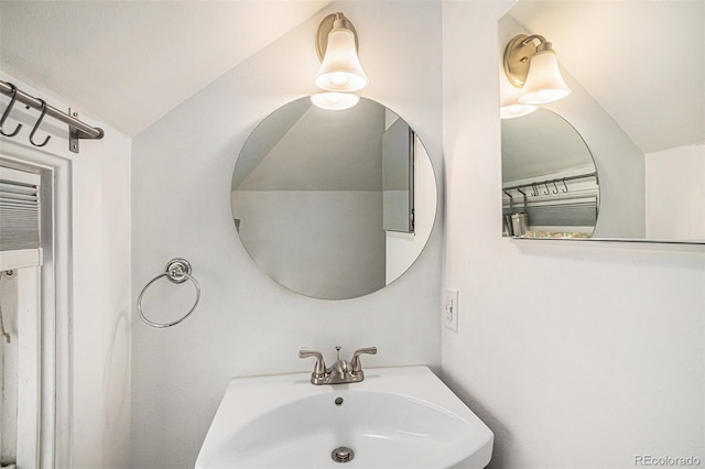 bathroom featuring vaulted ceiling and sink