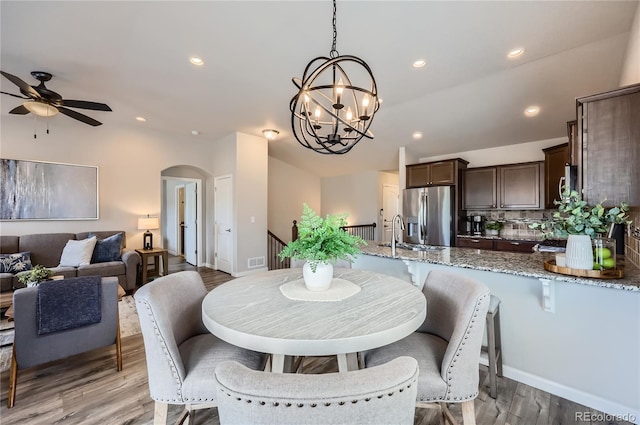 4318 Hessite Loop, Colorado Springs, CO 80938 - dining space featuring arched walkways, a ceiling fan, light wood-style floors, a chandelier, and recessed lighting