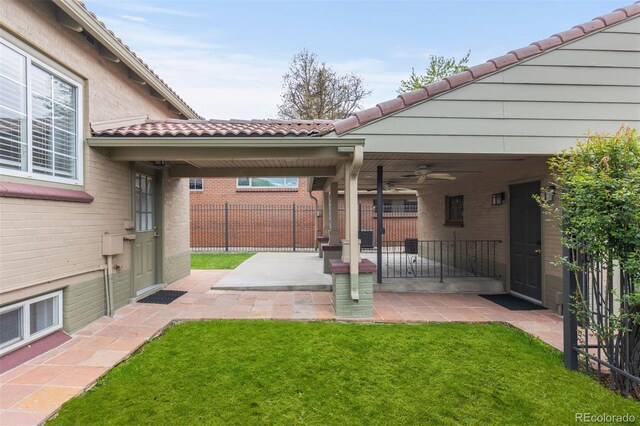view of yard featuring a ceiling fan and a patio area