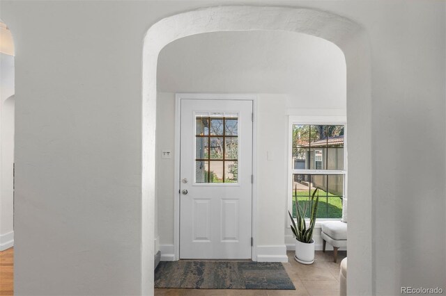 entryway featuring arched walkways and baseboards