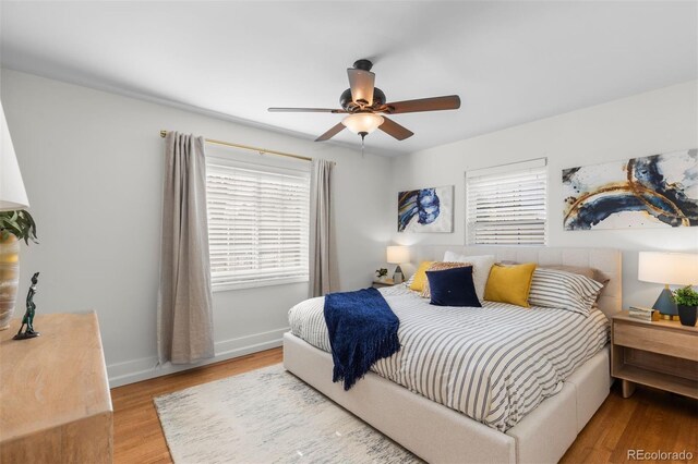 bedroom featuring wood finished floors, baseboards, and ceiling fan
