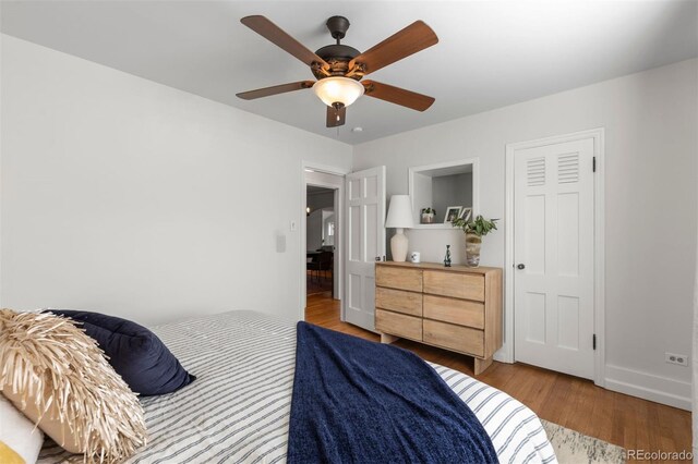 bedroom with wood finished floors, ceiling fan, and baseboards