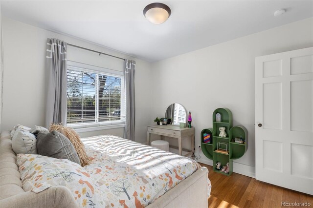 bedroom with wood finished floors and baseboards