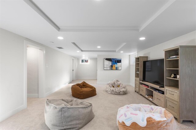 living area featuring a tray ceiling, recessed lighting, light carpet, and baseboards