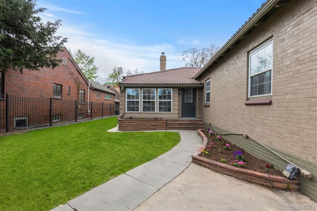 doorway to property featuring a chimney, a tiled roof, and brick siding