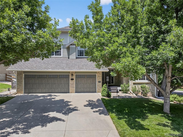 1 Amaranth Dr, Littleton, CO 80127 - obstructed view of property featuring roof with shingles, an attached garage, brick siding, and a front lawn