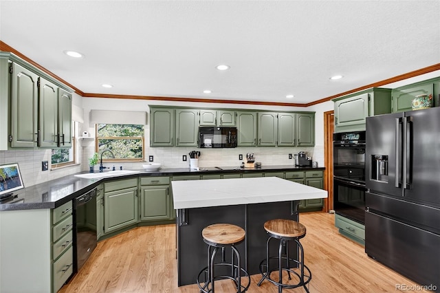 1 Amaranth Dr, Littleton, CO 80127 - kitchen featuring green cabinetry, black appliances, ornamental molding, light wood finished floors, and decorative backsplash