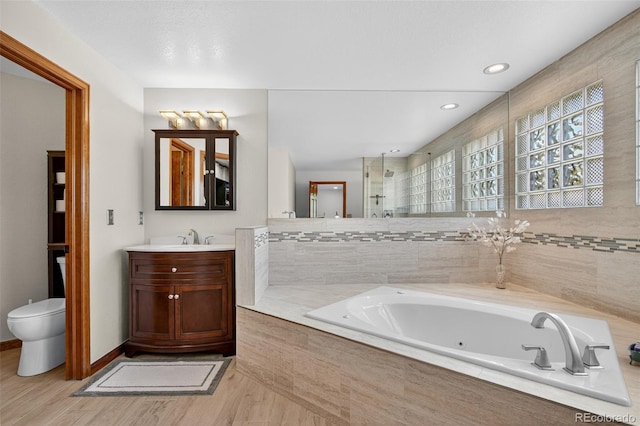 1 Amaranth Dr, Littleton, CO 80127 - bathroom featuring a whirlpool tub, wood finished floors, and vanity