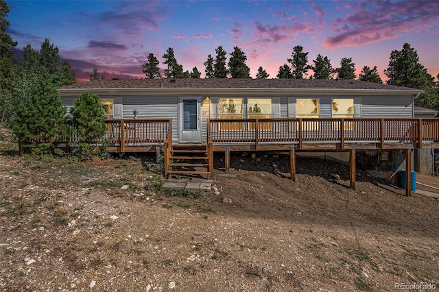 back house at dusk with a deck