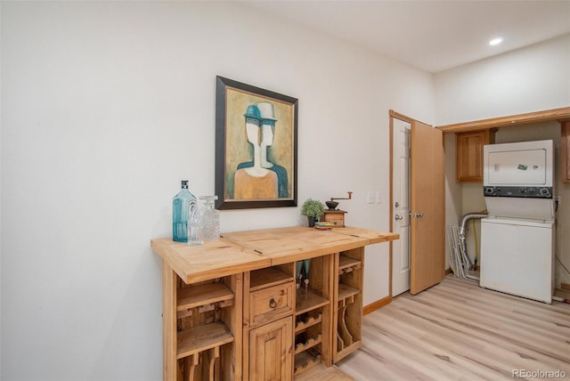 hall featuring light hardwood / wood-style flooring and stacked washer / drying machine