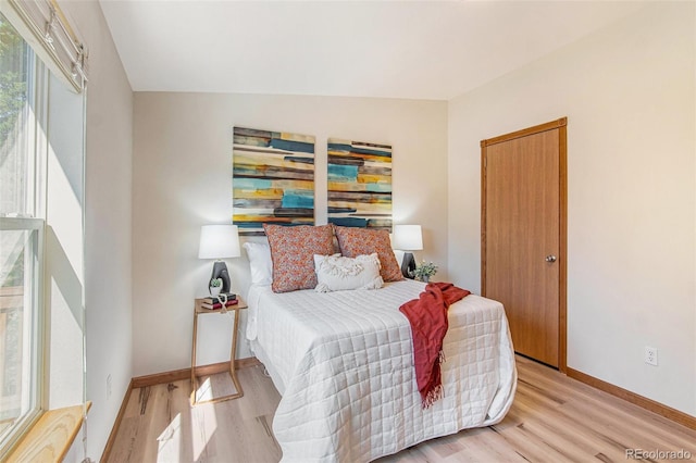 bedroom featuring light wood-type flooring and vaulted ceiling