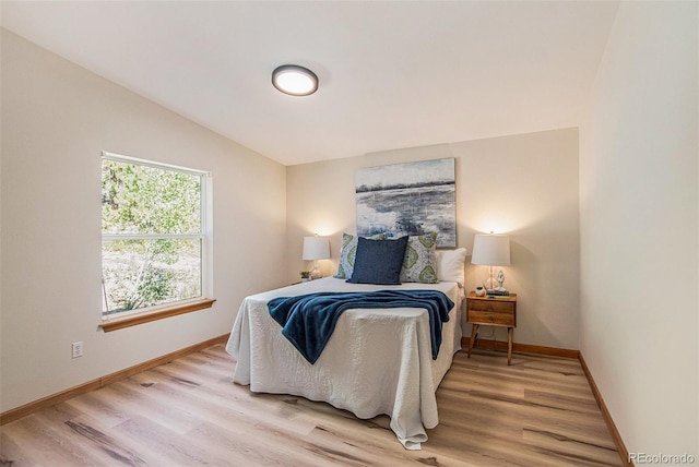 bedroom featuring vaulted ceiling and light hardwood / wood-style flooring