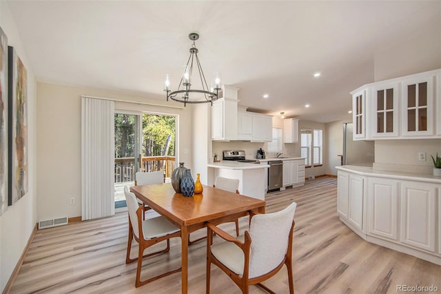 dining room featuring light hardwood / wood-style floors, a chandelier, and a wealth of natural light