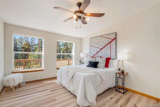 bedroom with ceiling fan, light wood-type flooring, and lofted ceiling