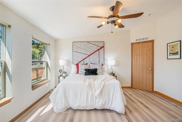 bedroom with ceiling fan, lofted ceiling, and light hardwood / wood-style floors