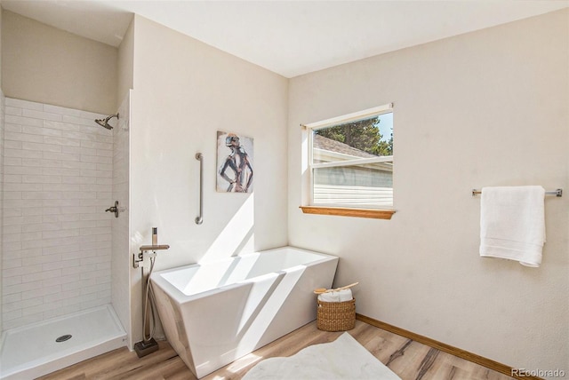 bathroom featuring hardwood / wood-style floors and plus walk in shower