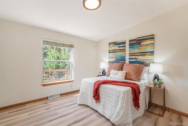 bedroom featuring light hardwood / wood-style flooring and vaulted ceiling