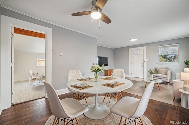 dining room with dark wood-type flooring, ceiling fan, and crown molding