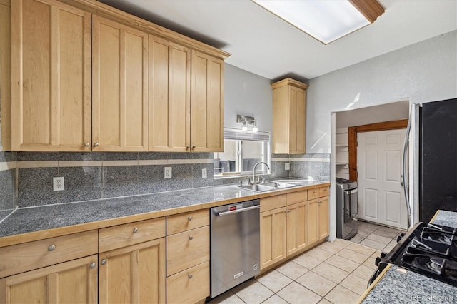 kitchen with stainless steel appliances, sink, tasteful backsplash, light brown cabinets, and light tile patterned floors