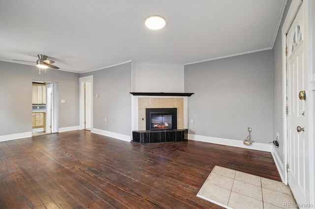 unfurnished living room featuring ceiling fan, hardwood / wood-style floors, crown molding, and a fireplace