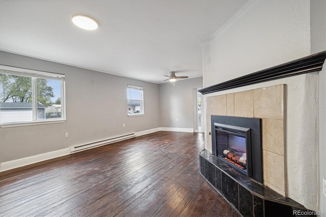 unfurnished living room featuring a fireplace, a baseboard radiator, dark hardwood / wood-style flooring, and plenty of natural light