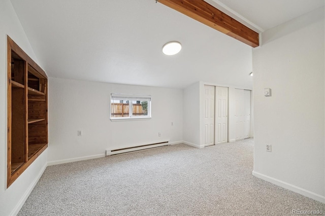 carpeted spare room with beamed ceiling and a baseboard heating unit