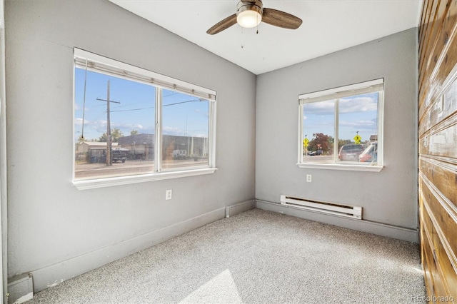 unfurnished room with a baseboard heating unit, carpet, ceiling fan, and plenty of natural light