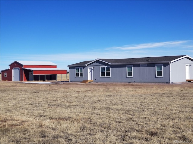 view of front facade featuring an outbuilding and a front yard