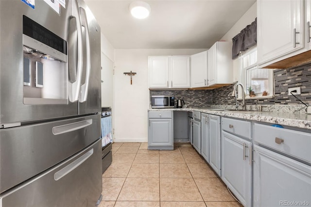 6871 Locust St, Commerce City, CO 80022 - kitchen featuring stainless steel appliances, decorative backsplash, gray cabinetry, and light tile patterned flooring