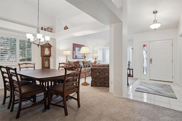 carpeted dining space with lofted ceiling and a chandelier