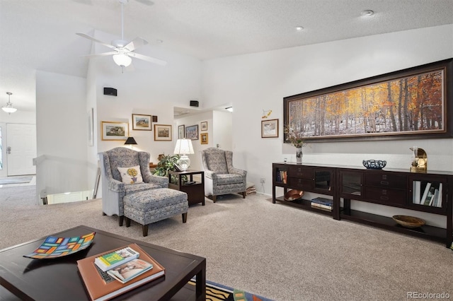 living room featuring ceiling fan, high vaulted ceiling, carpet flooring, and a textured ceiling